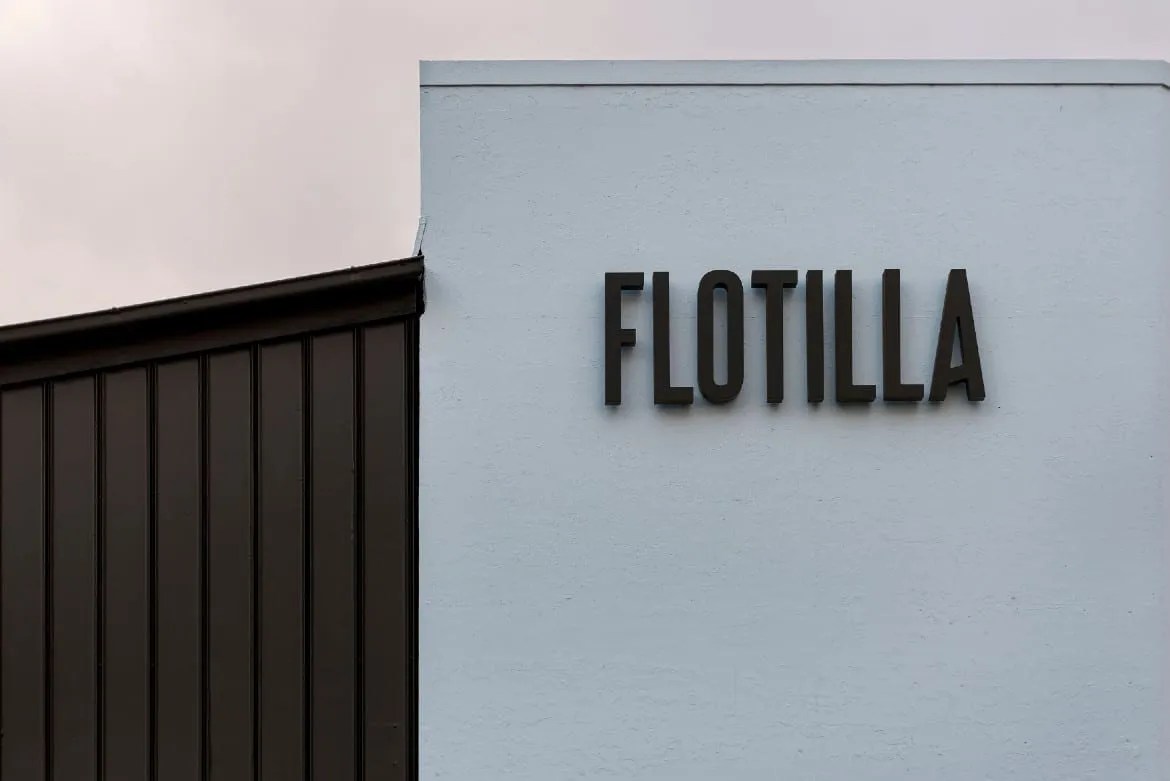 A sign that says flotilla on the side of a building.