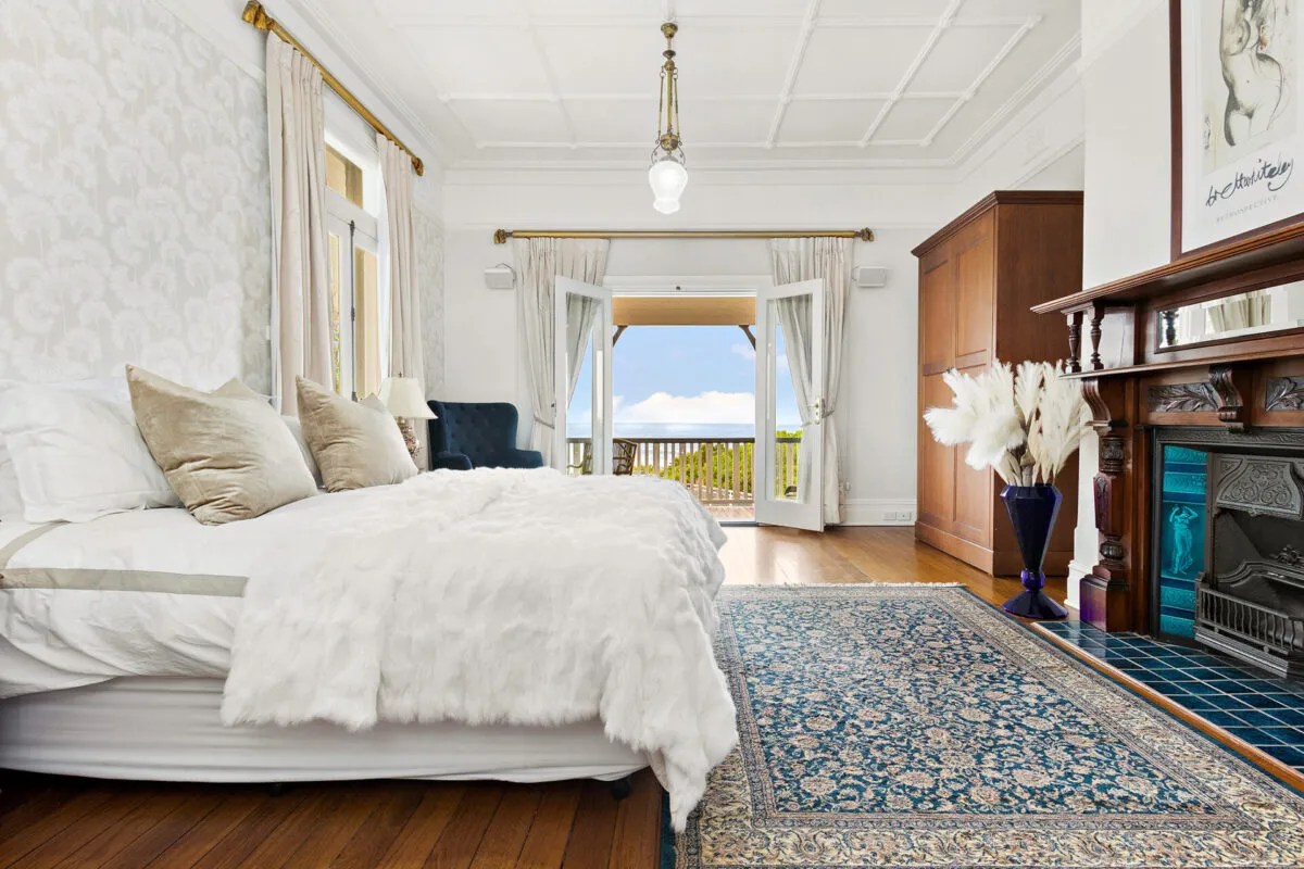 A bedroom with a fireplace and a rug.