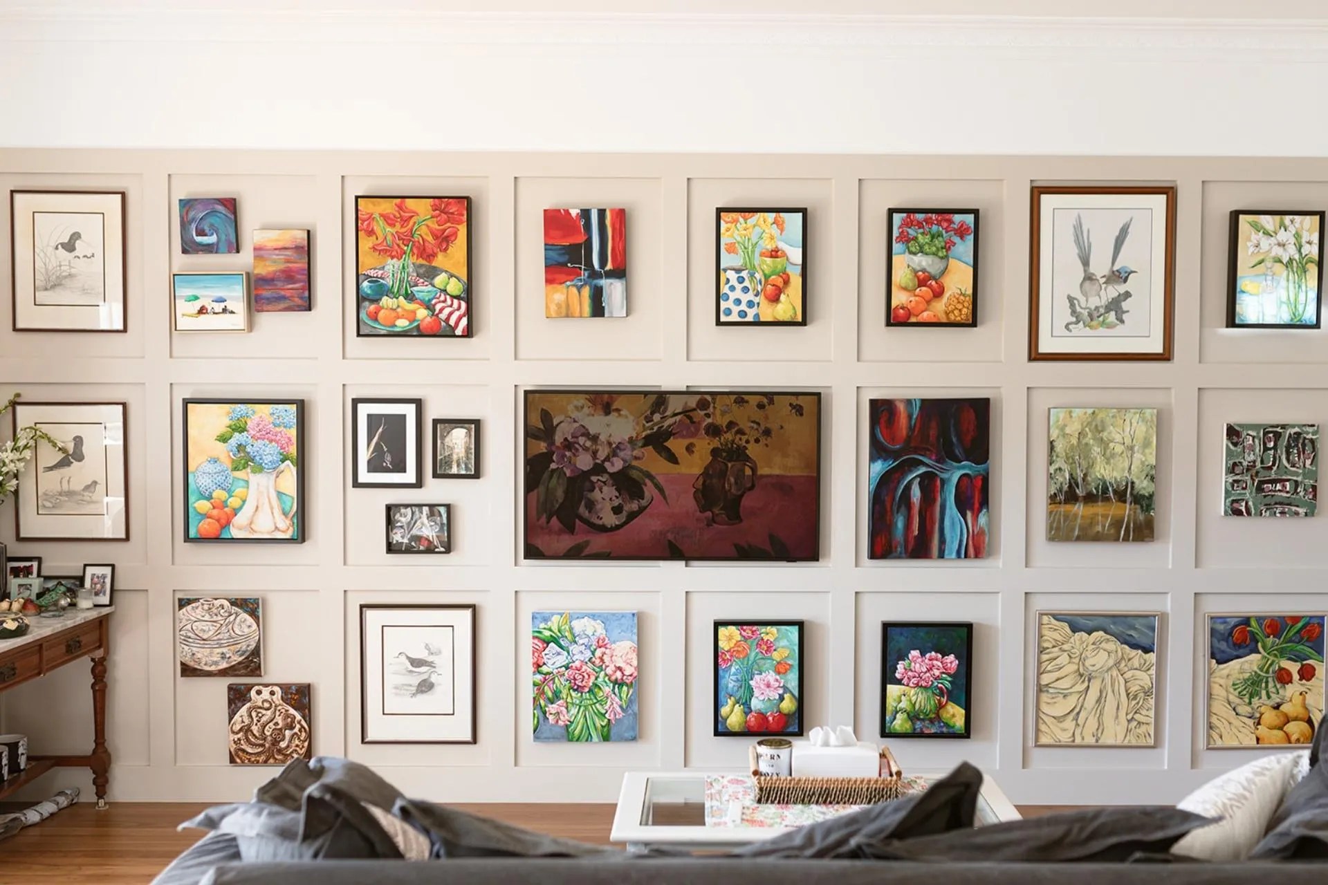 A living room with many framed pictures on the wall.