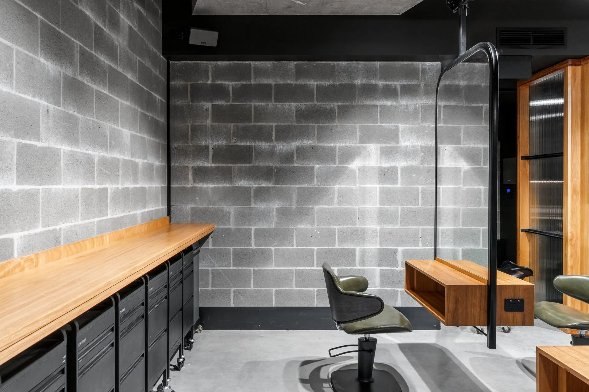 A hair salon with a brick wall and a mirror.