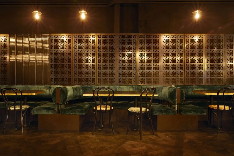 A restaurant with green booths and wooden walls.