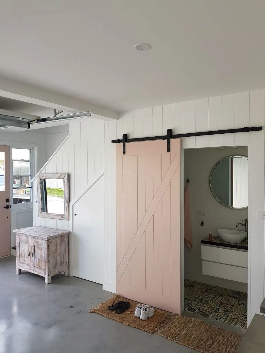 A room with a barn door and white walls.