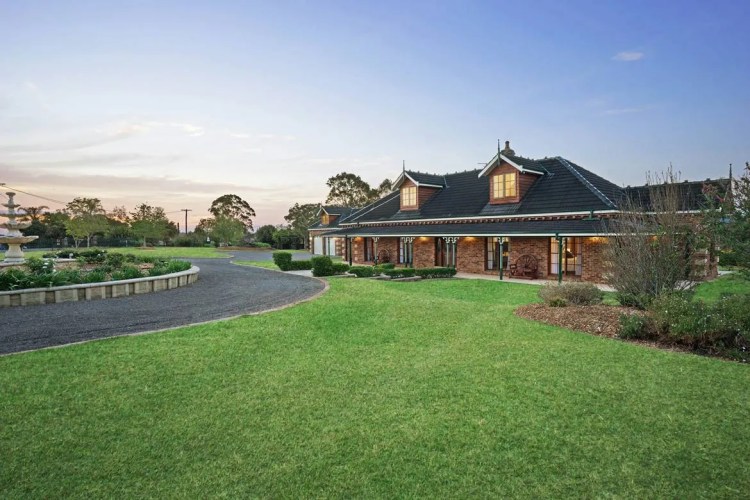 A house with a driveway and grass in front of it.