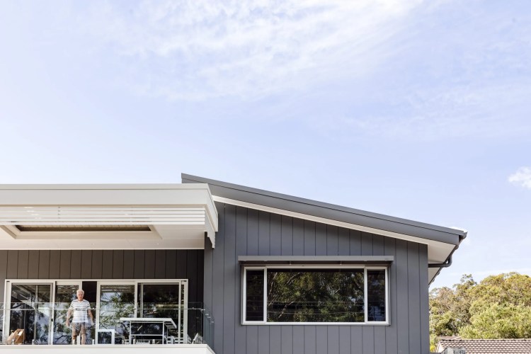 A house with a grey exterior and a large deck.